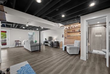 Spacious basement with seating area, office desk, and bathroom.