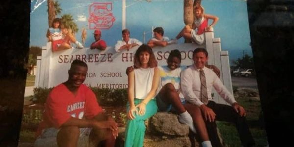 High school students posing in front of Seabreeze High School sign outdoors.