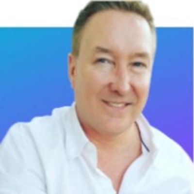 Smiling man in white shirt with blue gradient background.