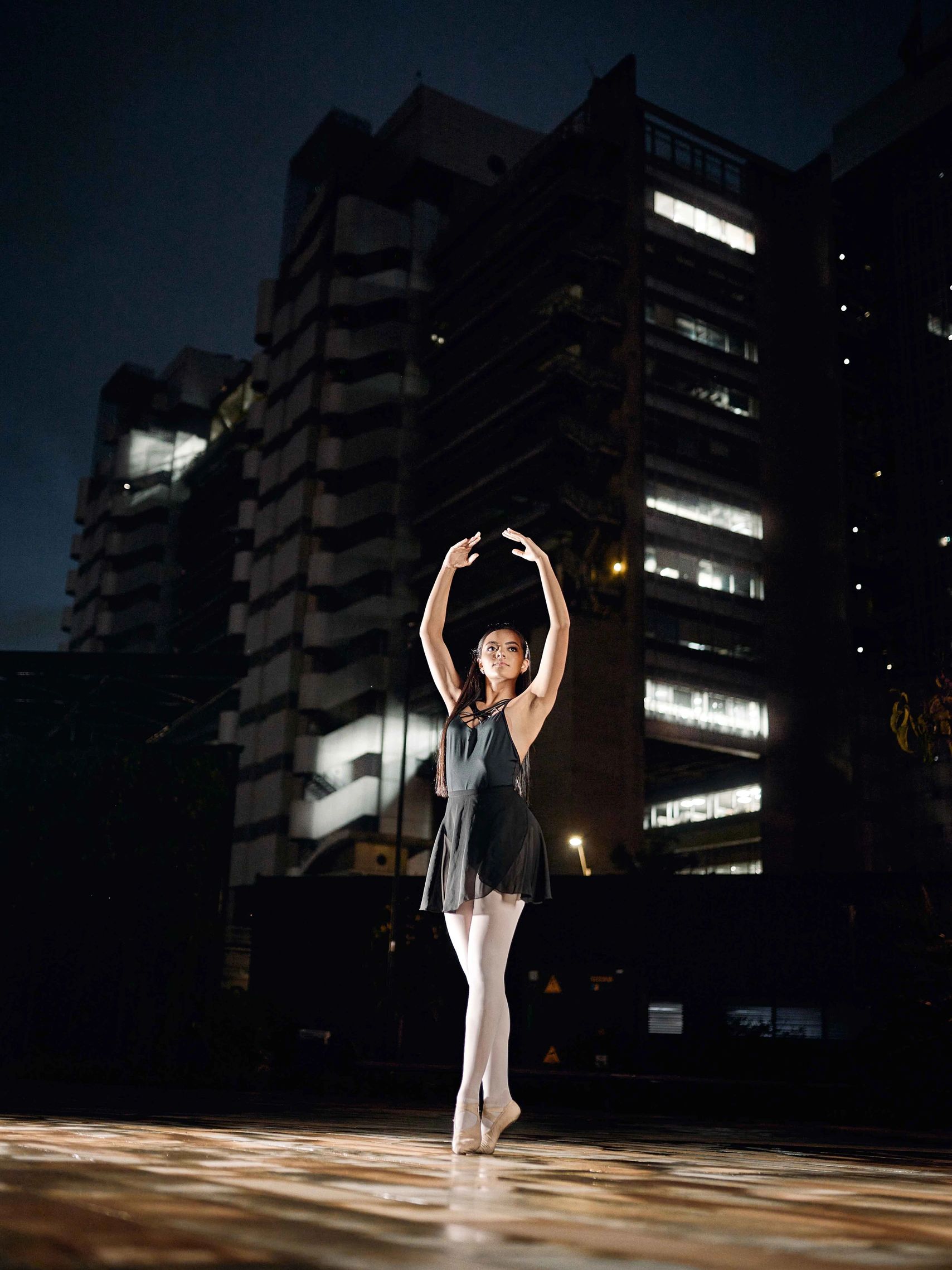 Quinceañera bailando ballet en medio de la noche en una plaza de la ciudad de Medellín