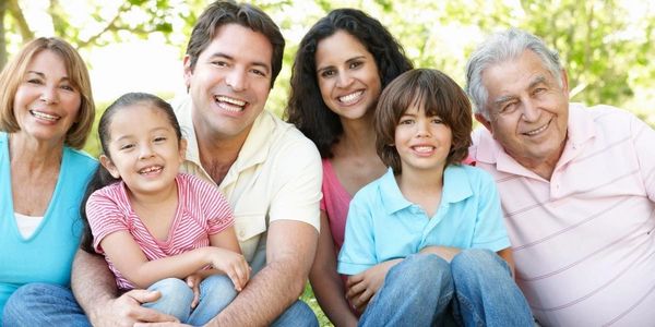 Multiple generations of smiling Spanish speaking Latino family after receiving a prestamo de titulo