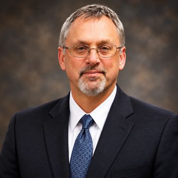 Professional middle-aged man in suit and glasses.