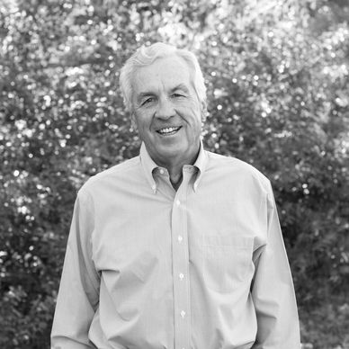 Smiling elderly man in outdoor setting.