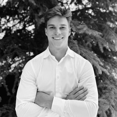 Smiling young man in white shirt outdoors.