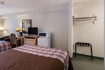 Cozy hotel room with patterned bedding and essential appliances.