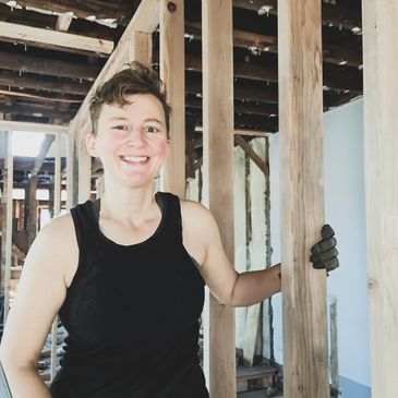 Rebecca is standing in construction site and smiling.