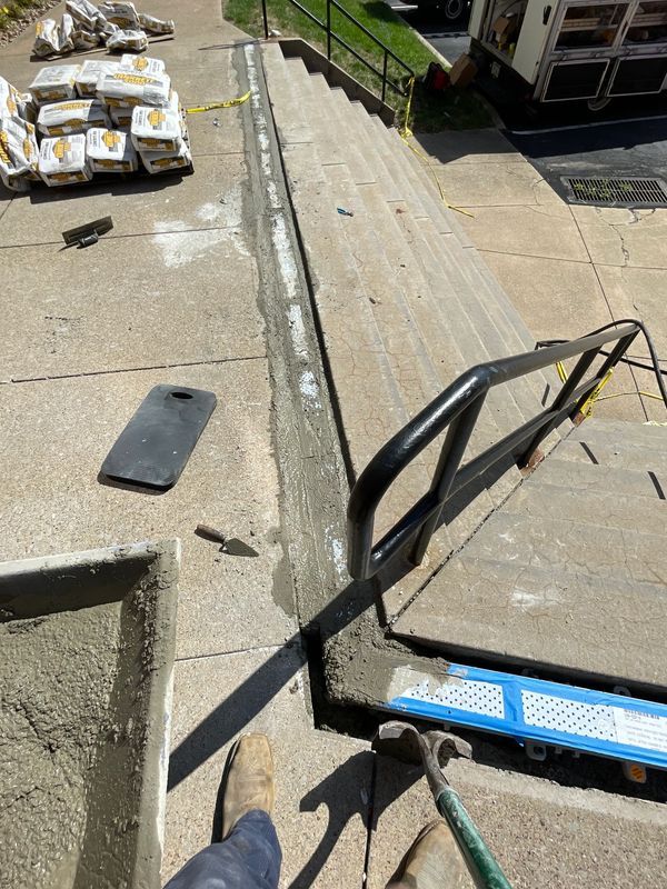 Concrete repair work being done on sidewalk and stairs outdoors.for new trench drains