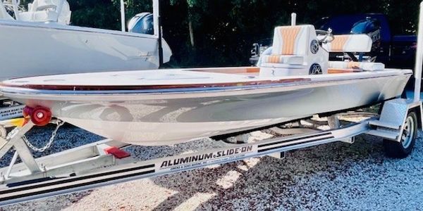 A sleek white speedboat on a trailer.
