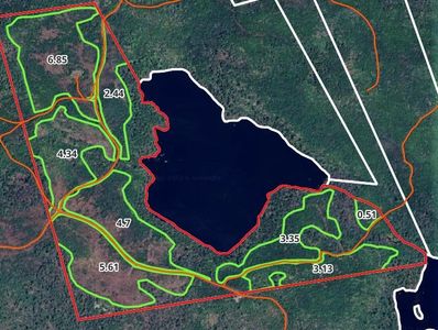Aerial map showing a lake surrounded by land plots with area measurements.