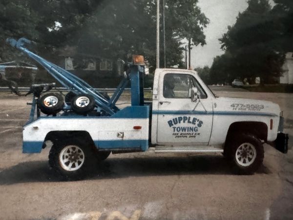 Vintage Rupple's Towing truck parked on a street.
