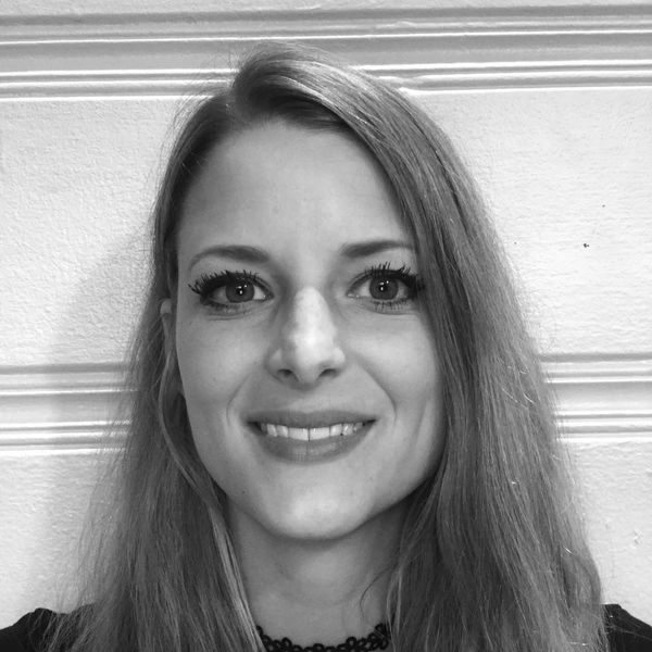 Smiling woman with long hair in black and white photo.