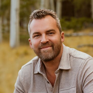 Dan Harrah, owner of Harrah Advisory Services, outdoors in an autumn forest setting.