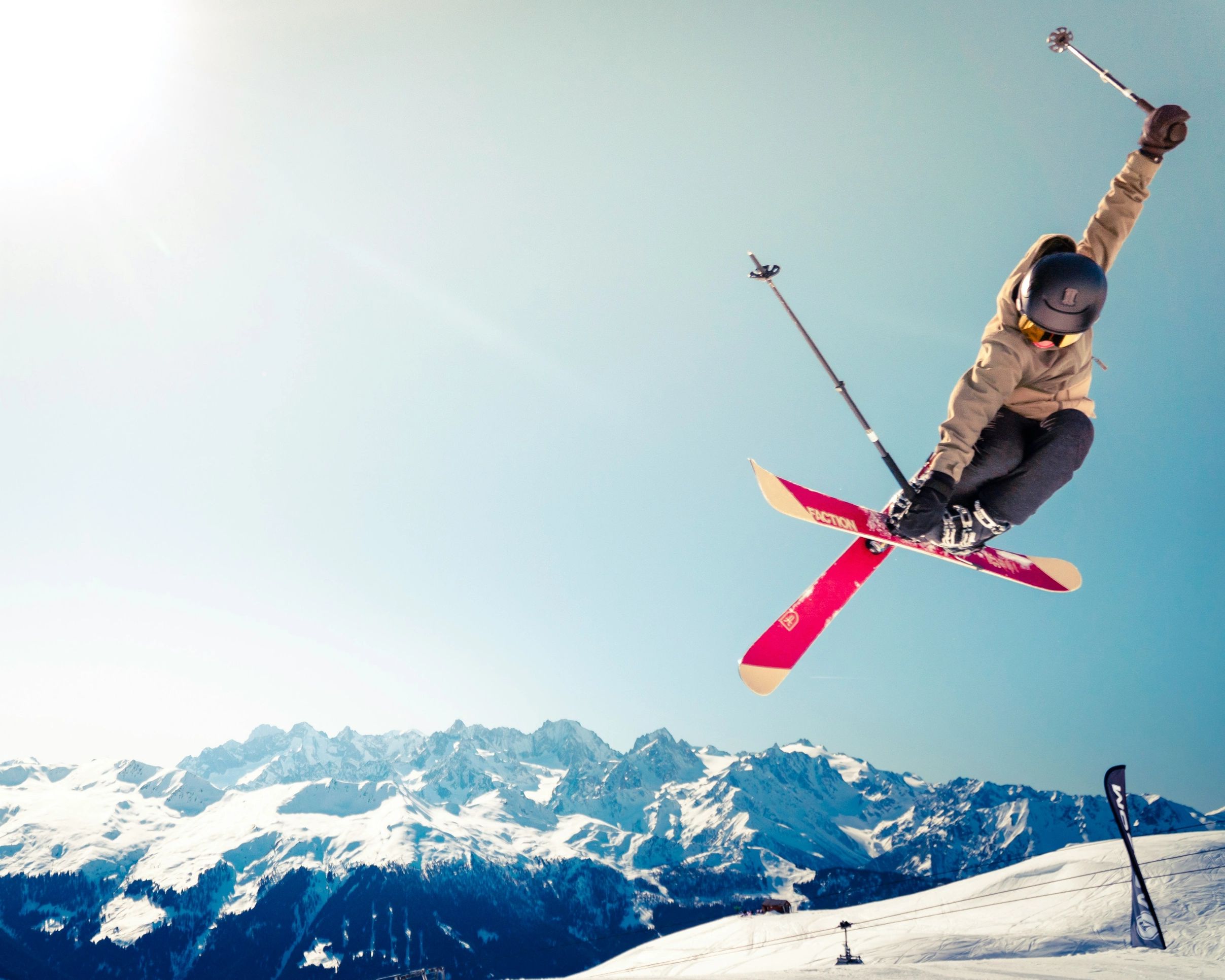 A person flying through the air on skiis performing what looks like a jump or trick of some kind