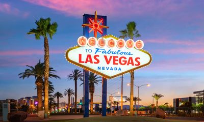 The iconic Welcome to Fabulous Las Vegas sign at sunset with palm trees.