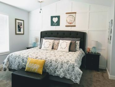 Cozy bedroom with a floral bedspread and decorative pillows.