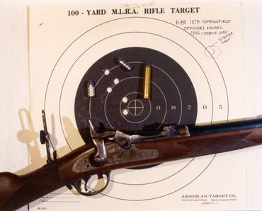 45-70 rifle with rear sight, bullet, cartridge and target
