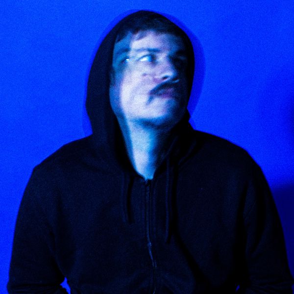 Homem com hoodie preto em fundo azul com efeito visual desfocado dupla exposição.