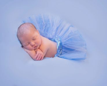 baby girl in blue tutu on a blue background