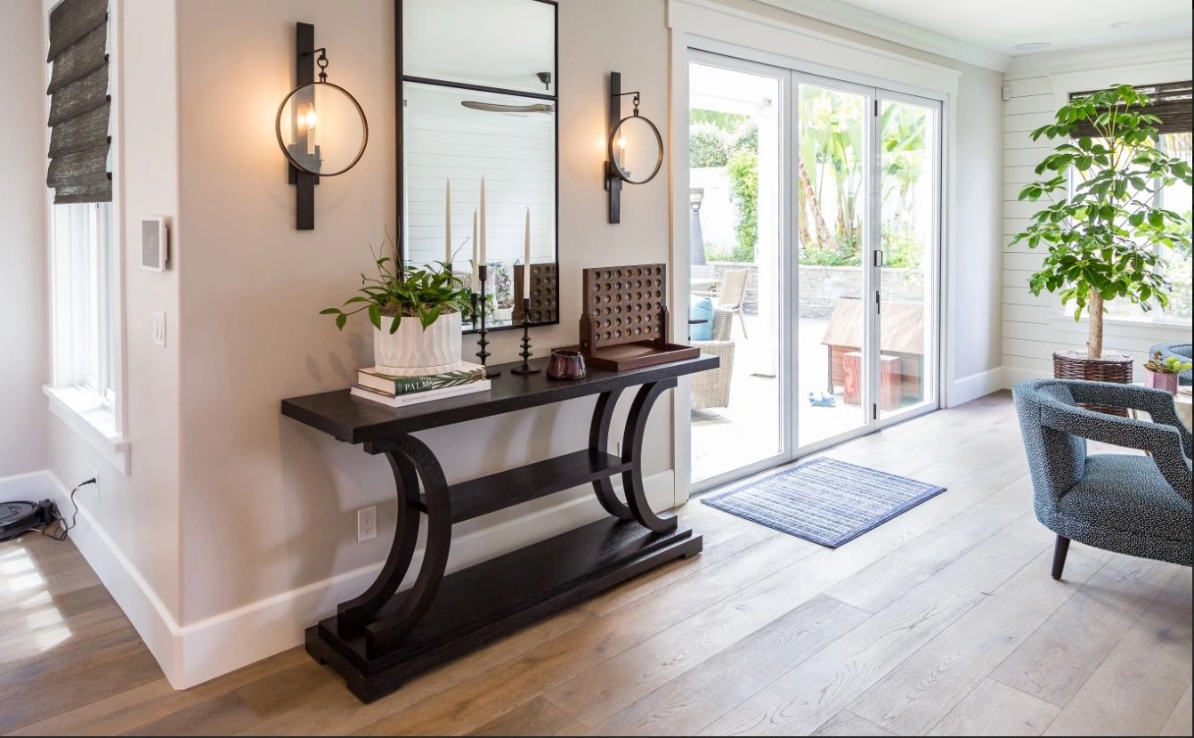Modern entryway with a console, mirror, and large sliding glass door.