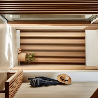 Minimalist hallway with wooden slats, a bench, and a hat hanging on the wall.