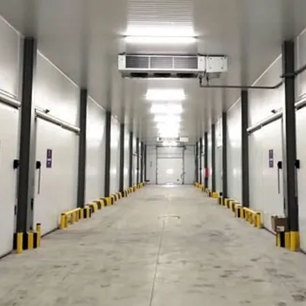 Long corridor with multiple industrial doors and bright ceiling lights.
