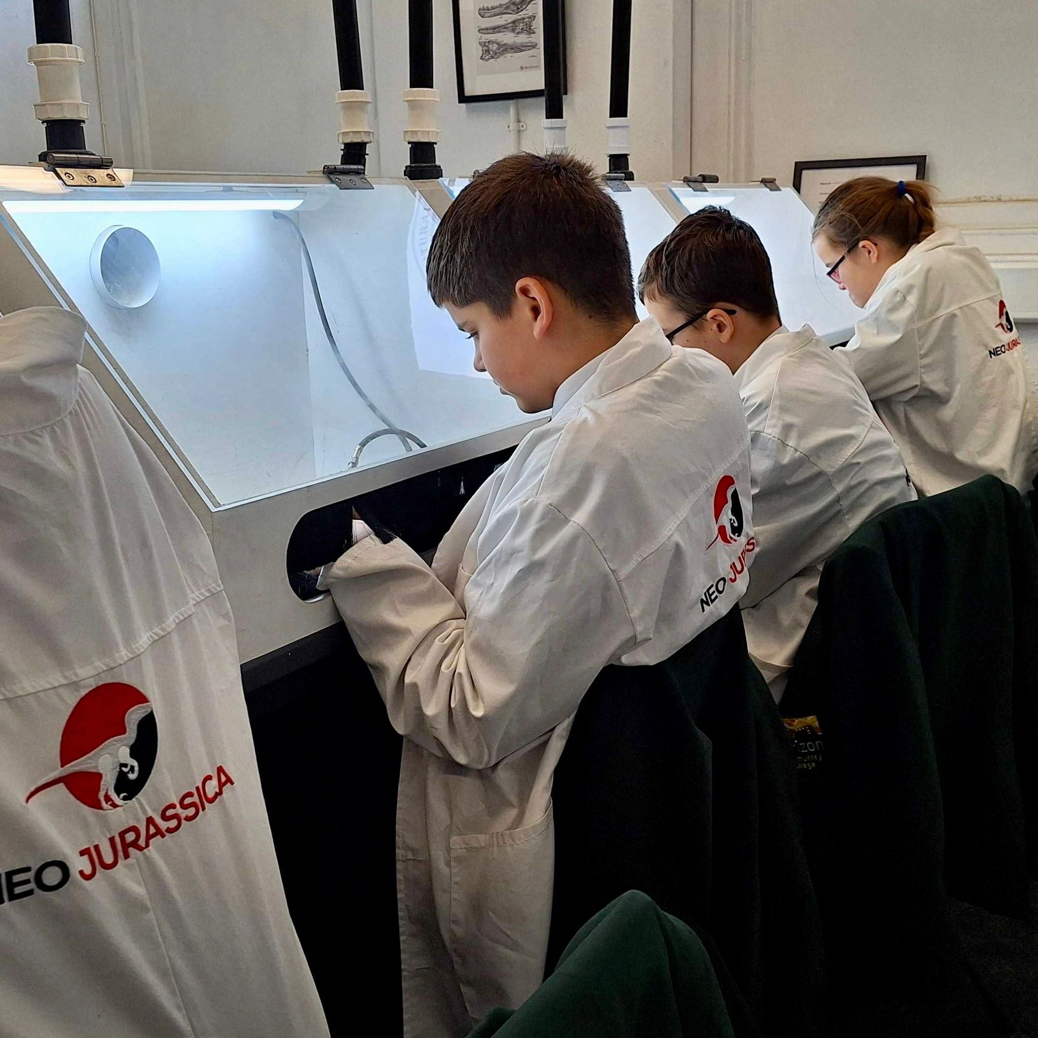 Students in lab coats working attentively at laboratory stations.