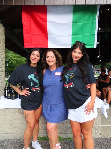 Three women posing together under an Italian flag.