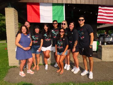 Group of people posing with Italian and American flags.