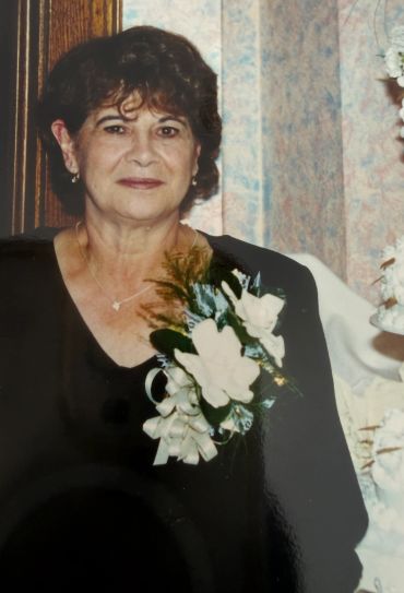 Elegant older woman with floral corsage.