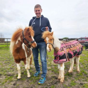 Matt holding two miniature ponies either side of him