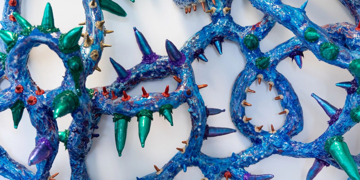 Blue sculpture with colorful spikes.