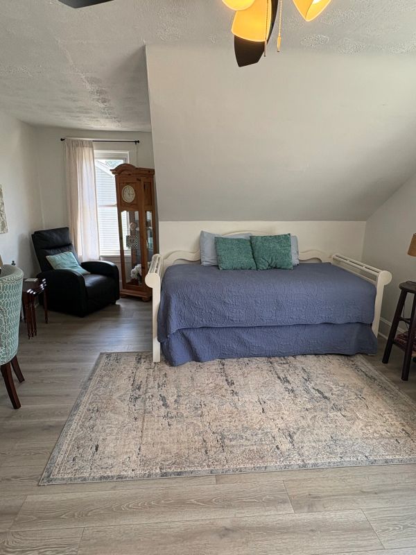 Cozy bedroom with a blue bedspread and wooden furniture.