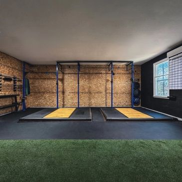 Modern gym area with lifting platforms and equipment.