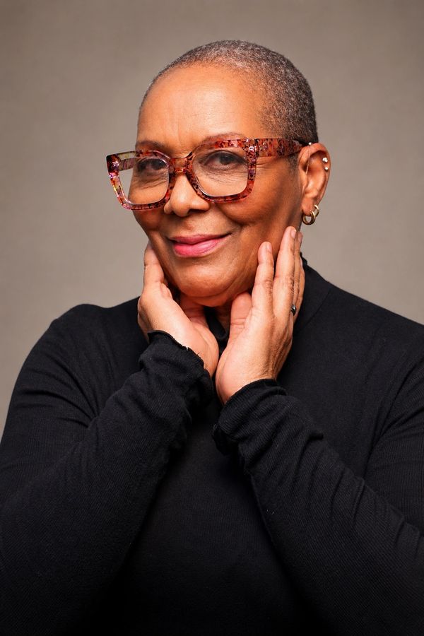 Confident woman with stylish glasses and a warm smile.