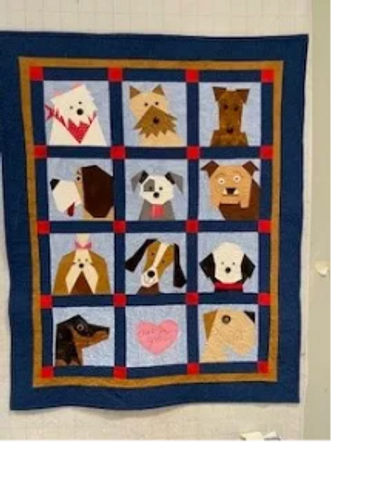 Quilt featuring twelve different dog faces in colorful patchwork.