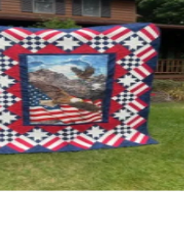 A patriotic quilt featuring an eagle and American flag outdoors.