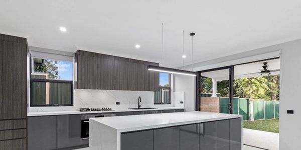 Modern kitchen with sleek dark cabinetry and a large marble island.