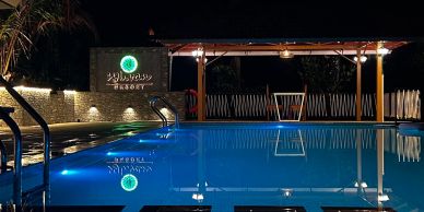 Night view of a serene resort swimming pool with lights.