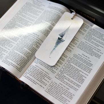 Open Bible with a sailboat-themed bookmark resting on the pages.