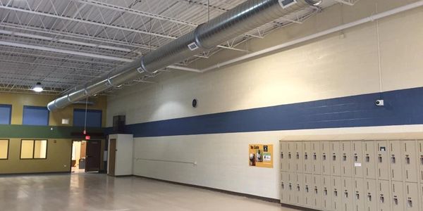 An image of the inside of a school, showing lockers in a hallway