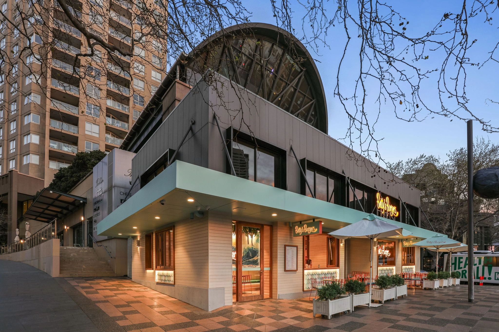 Exterior of Betzy's Burgers restaurant with outdoor seating in an urban area.