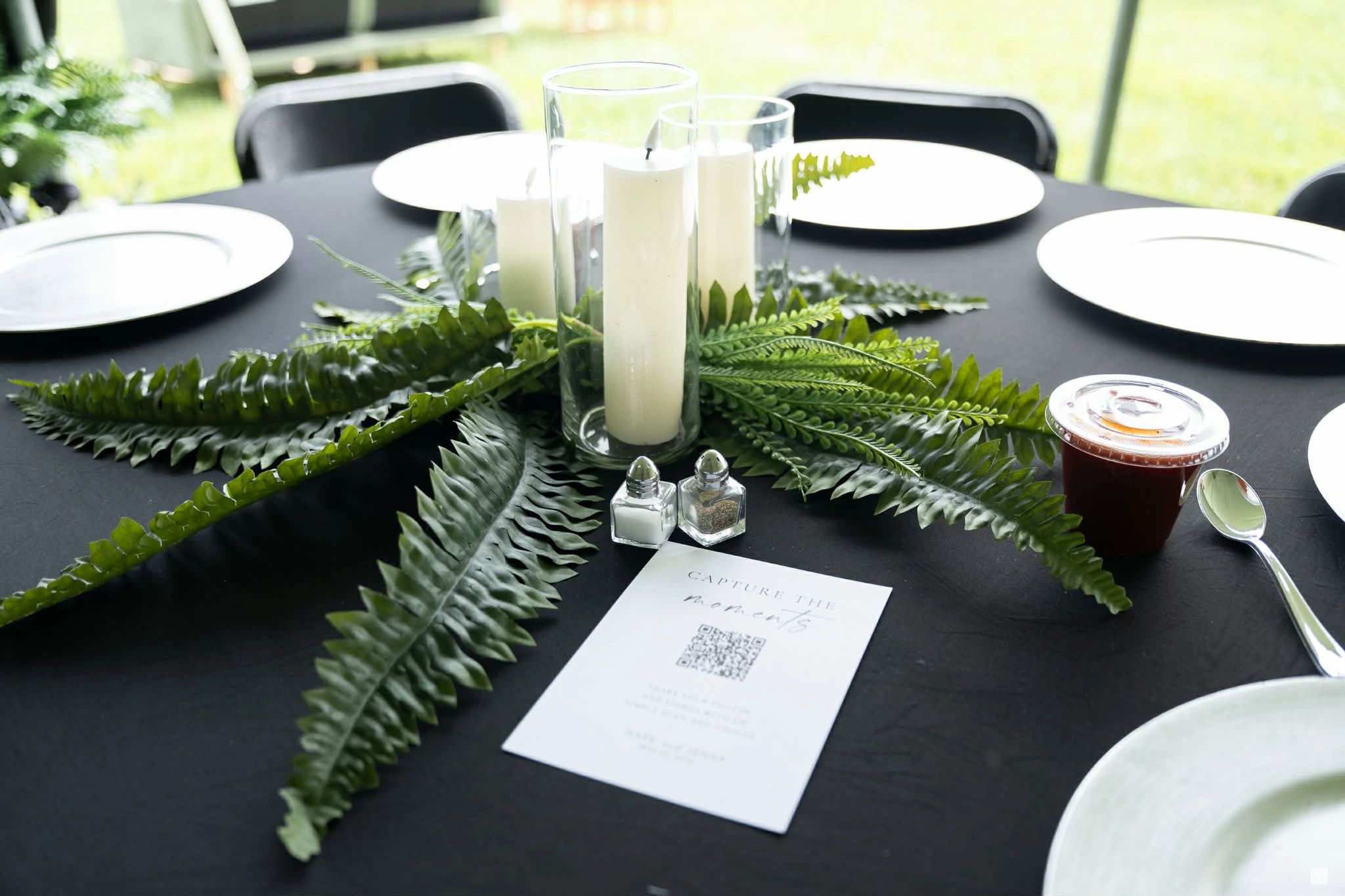 Elegant table setting with candles and greenery centerpiece.