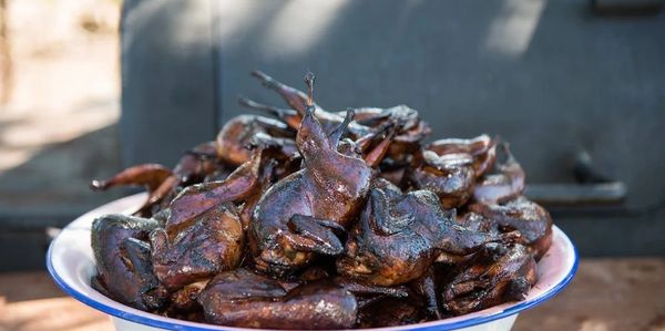 A bowl filled with roasted birds, likely quail or similar small game.