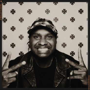 Man smiling and making peace signs with both hands.