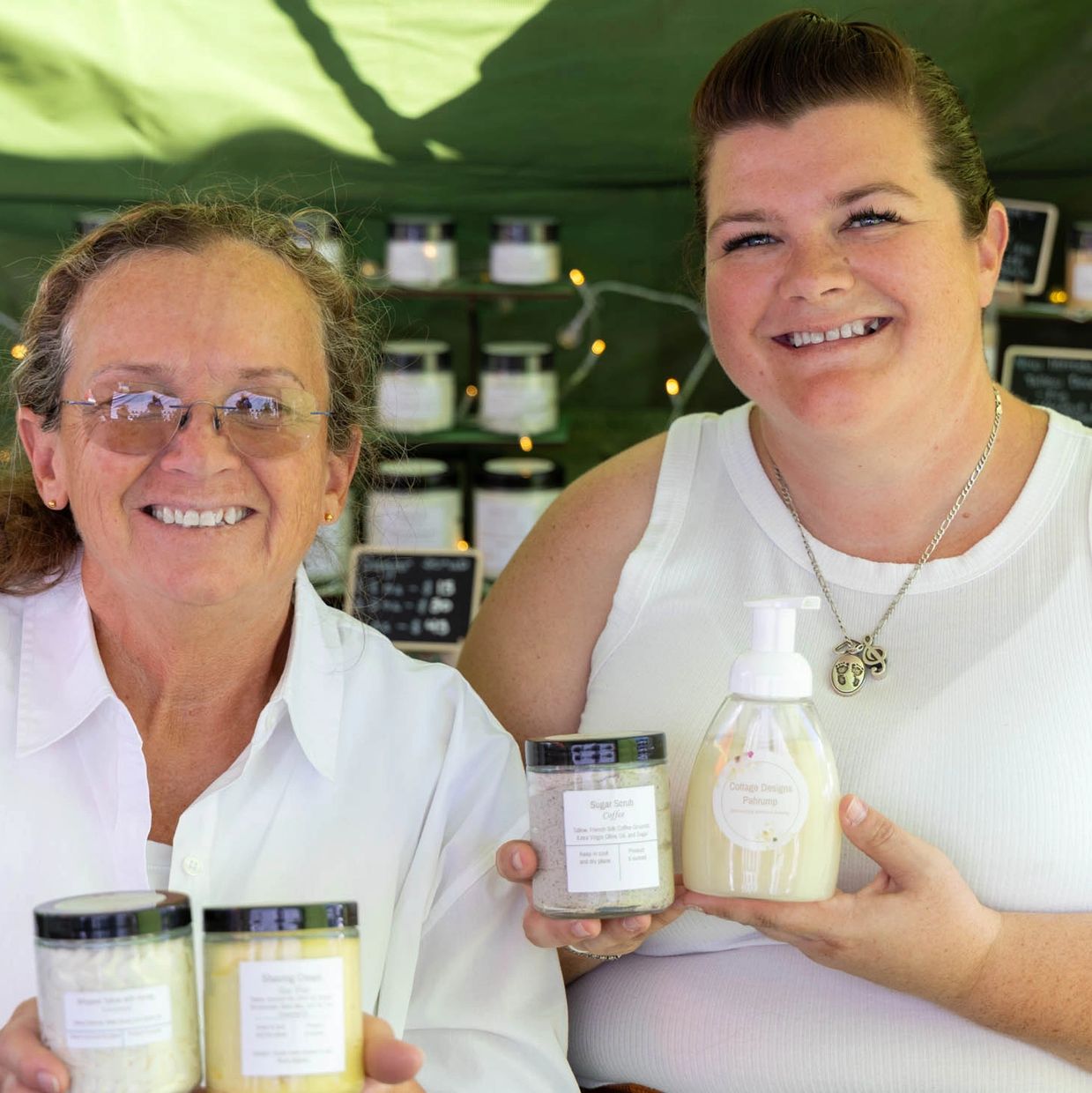two women smiling woth skincare products in hand