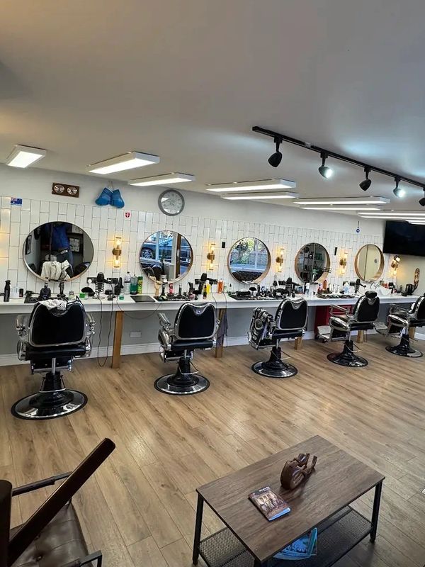 Modern barbershop with multiple styling stations and cozy seating area.