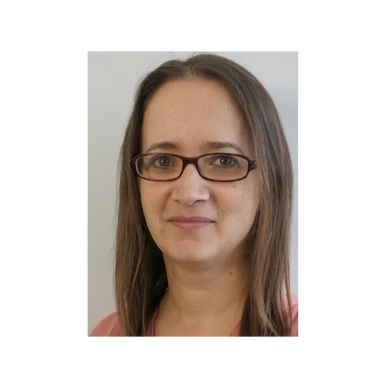 Photo of Cara Wilkie, a white woman with long brown hair and glasses.