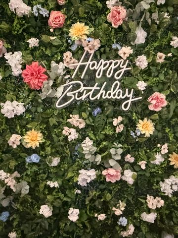 Floral wall with "Happy Birthday" sign.