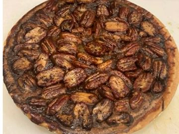 Homemade pecan pie with a golden-brown crust and toasted pecans on top.