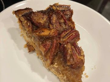 A slice of pecan pie on a white plate.